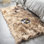 Tapis beige en fausse peau de mouton à poils longs Malaiah