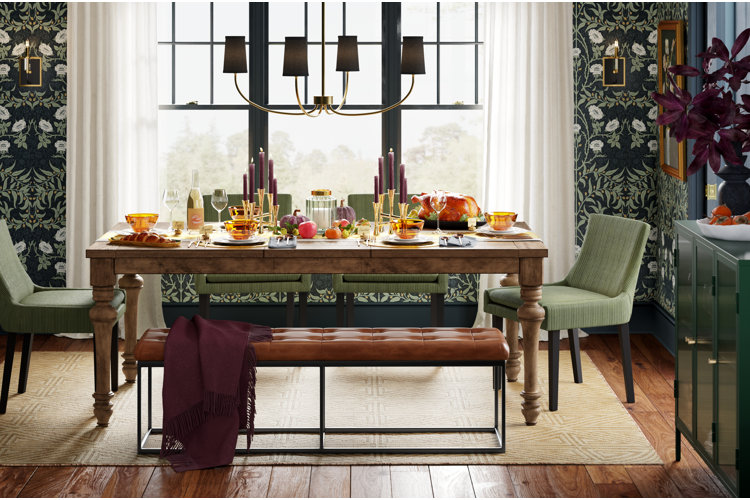 how to host Thanksgiving with these simple tips; dining room with dark green wallpaper, wood dining table, and a fabric-shaded chandelier
