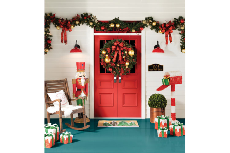 front porch decorated with outdoor Christmas garlands, lights, and decor
