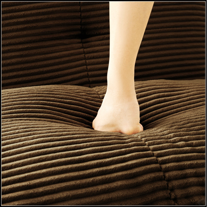 Canapé modulable sans accoudoirs, recouvert d'un tissu en velours côtelé moelleux et doté de coussins de soutien pour une configuration flexible des sièges dans le salon.