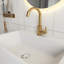 Meuble-lavabo blanc en panneau de fibres à densité moyenne de 20 po avec lavabo en céramique, porte à motif de losanges, poignée dorée et tablettes de rangement latérales avec barre à serviettes-406380546