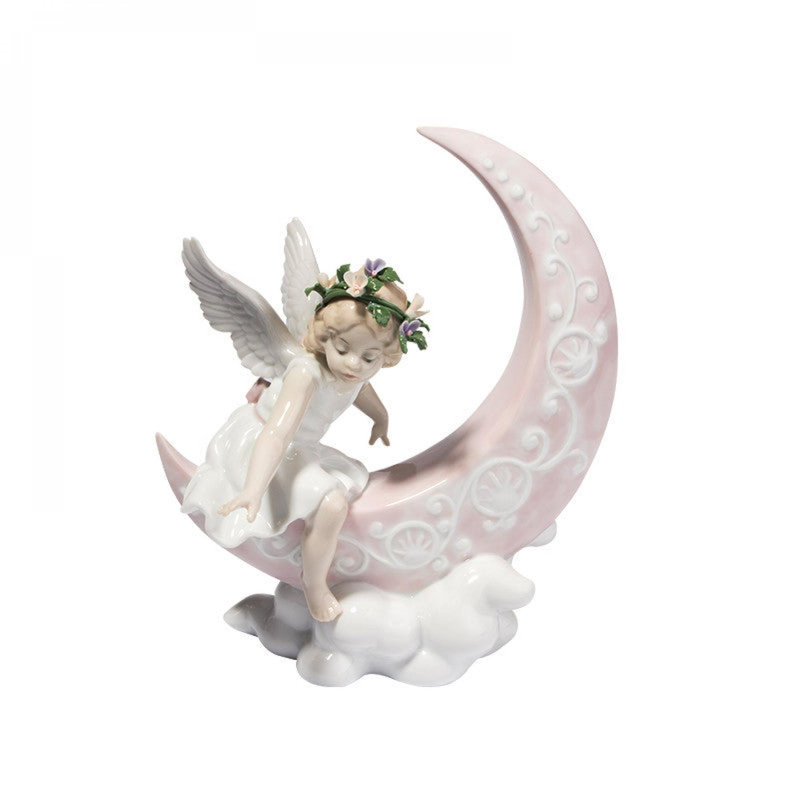 Figurine de fée assise sur un quart de lune