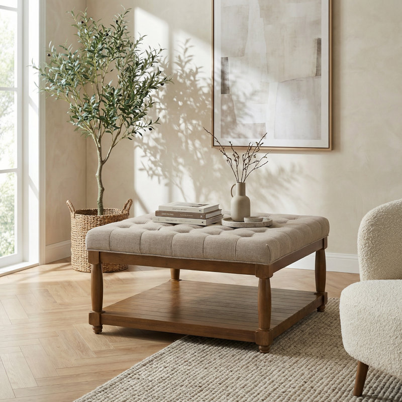 Grand repose-pieds capitonné carré rembourré avec tablette en bois massif et coussin rembourré pour une utilisation polyvalente comme table basse ou repose-pieds dans des tons neutres classiques