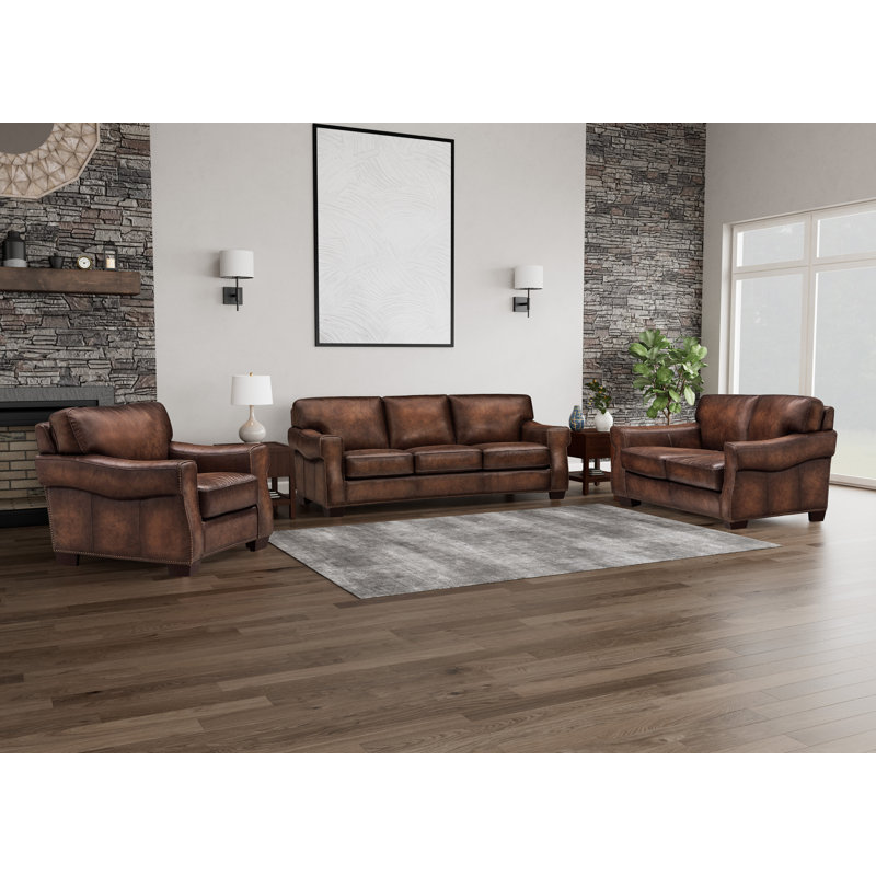 Fauteuil Capri en cuir pleine fleur ciré, dossier capitonné et garniture cloutée