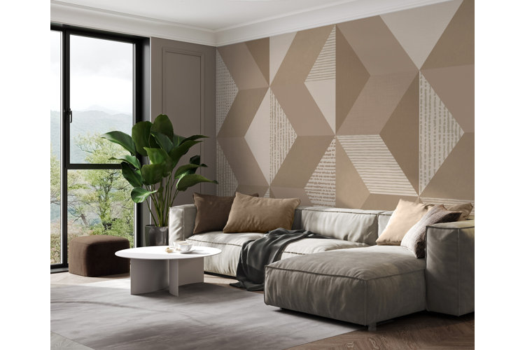 modern living room with a beige and ivory geometric-patterned accent wall, ivory area rug, light gray couch, and brown throw pillows
