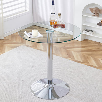 Un plateau de table en verre d'un diamètre de 35 pouces et une table de salle à manger circulaire minimaliste moderne avec des pieds en métal argenté électrolytique.