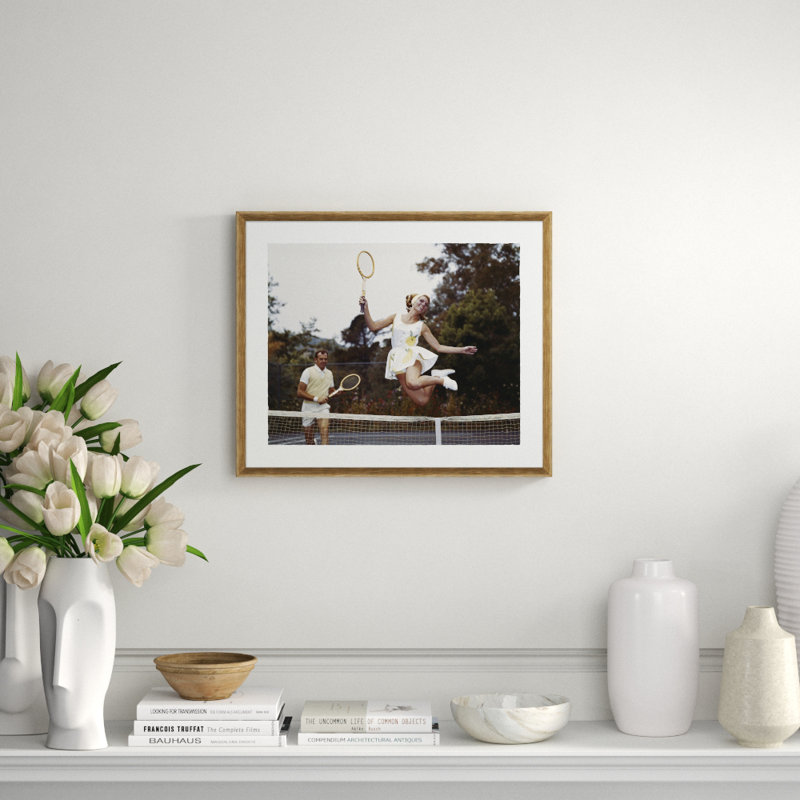 Couple On Tennis Court, Woman Jumping In Foreground Giclee Print by Getty Images