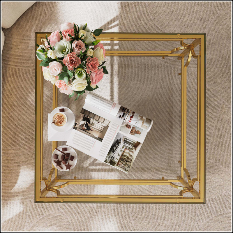 Table basse carrée en verre avec cadre luxueux en métal géométrique, finition dorée et tablette inférieure pour des espaces de vie élégants