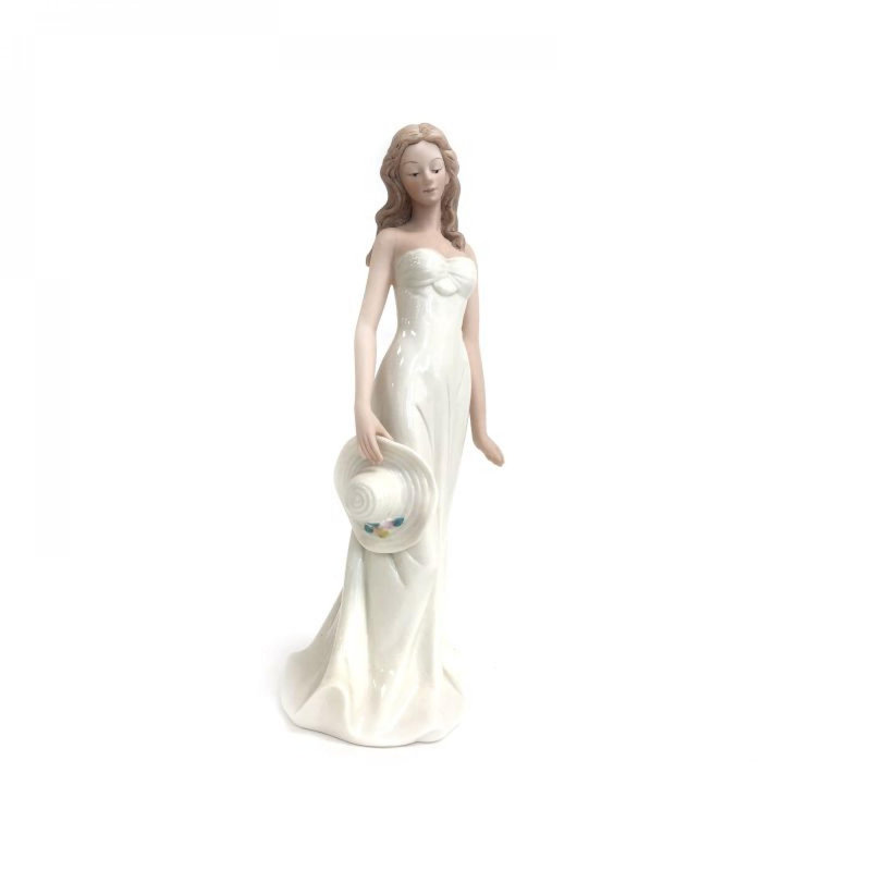Figurine Dame en blanc tenant un chapeau