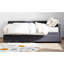 Lit simple tapissier en forme de L gris avec rangement. Revêtement en velours doux, tête de lit. Tiroirs pour la literie et les vêtements supplémentaires. Décoration latérale pour livres. Construisez une tête de lit confortable