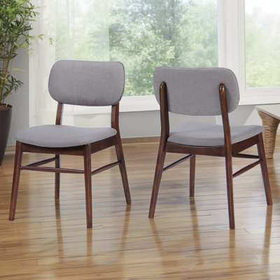 Deux ensembles de chaises de salle à manger rembourrées de style Mid-Century, avec des cadres en bois d'hévéa et des palettes de couleurs gris clair, combinent confort et ambiance rétro.
