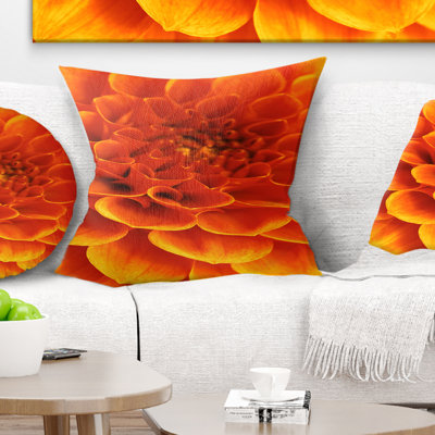 Coussin imprimé floral orange avec fleurs et pétales abstraits