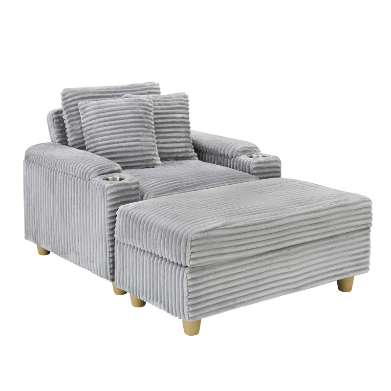 Grey corduroy single sofa with one pillow, two throw pillows, a footstool and two storage Spaces.
