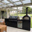 Îlot de cuisine extérieure modulaire de 109 pouces avec barbecue à gaz 6 brûleurs de 85 000 BTU, four à pizza de 35 000 BTU, comptoir en granit noir, évier, réfrigérateur extérieur et ensemble de rôtisserie.