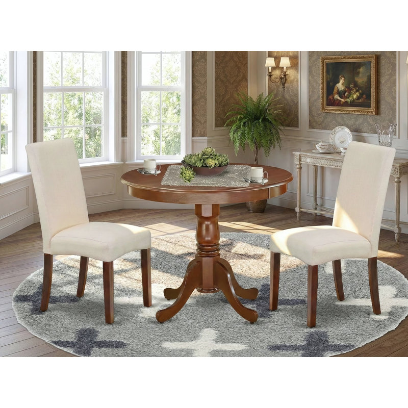 L'ensemble 3 pièces de table et chaises de cuisine comprend une table de salle à manger ronde avec piédestal et 2 chaises de salle à manger Parson en tissu crème, acajou