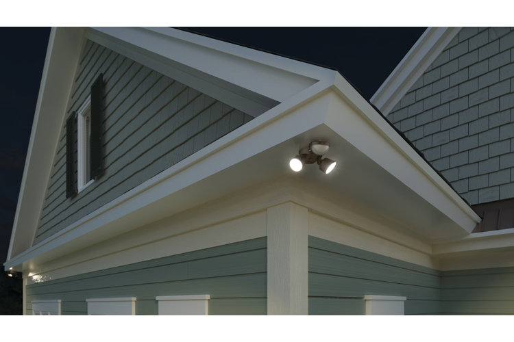 a two-light spotlight on the side of a gray shingled house