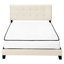 Grand lit en bois massif avec revêtement beige et tête de lit tapissier