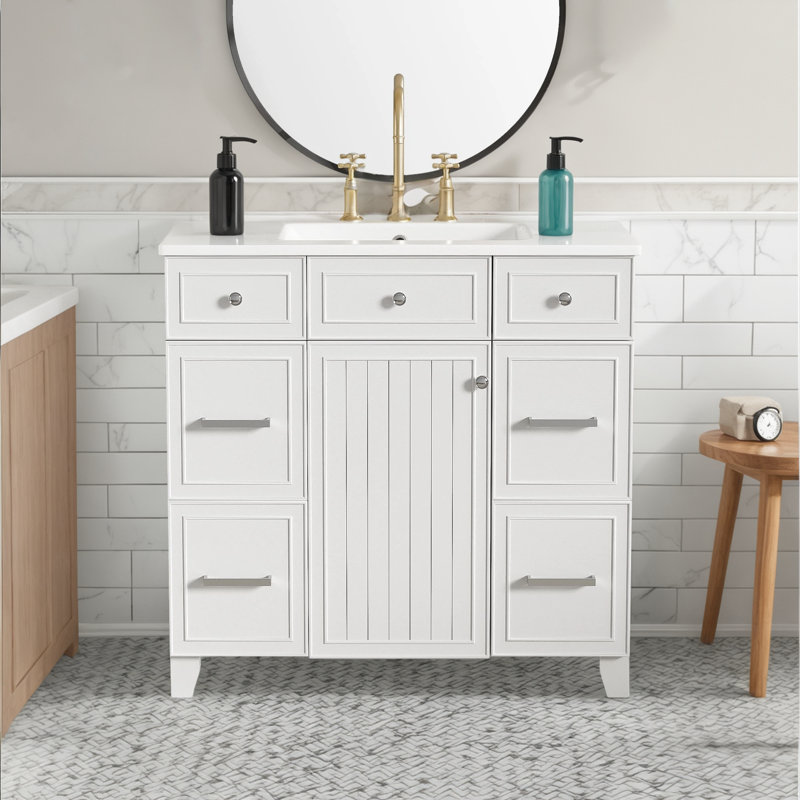 Le meuble-lavabo comprend un lavabo en céramique, un cadre en bois massif avec des portes à fermeture en douceur et des tablettes réglables, et 3 tiroirs, y compris un tiroir à double profondeur pour un sèche-cheveux.