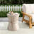 Lightweight Concrete Indoor Outdoor Side Table With Travertine Finish And Hourglass Silhouette For Versatile Use.