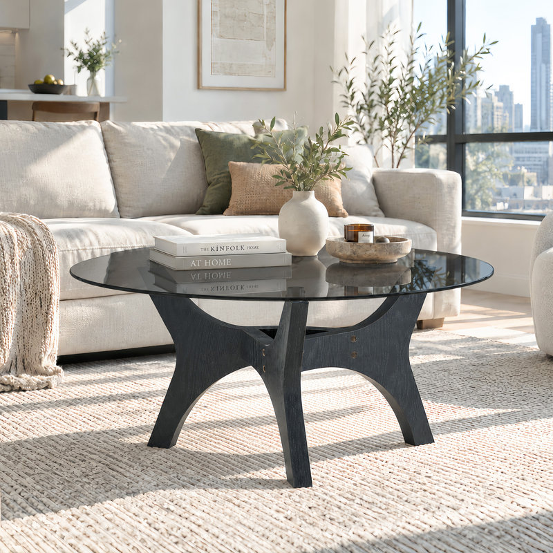 Table basse ronde en verre de 80 cm (31,5 po) avec plateau en verre noir fumé et piètement sculptural aspect bois.