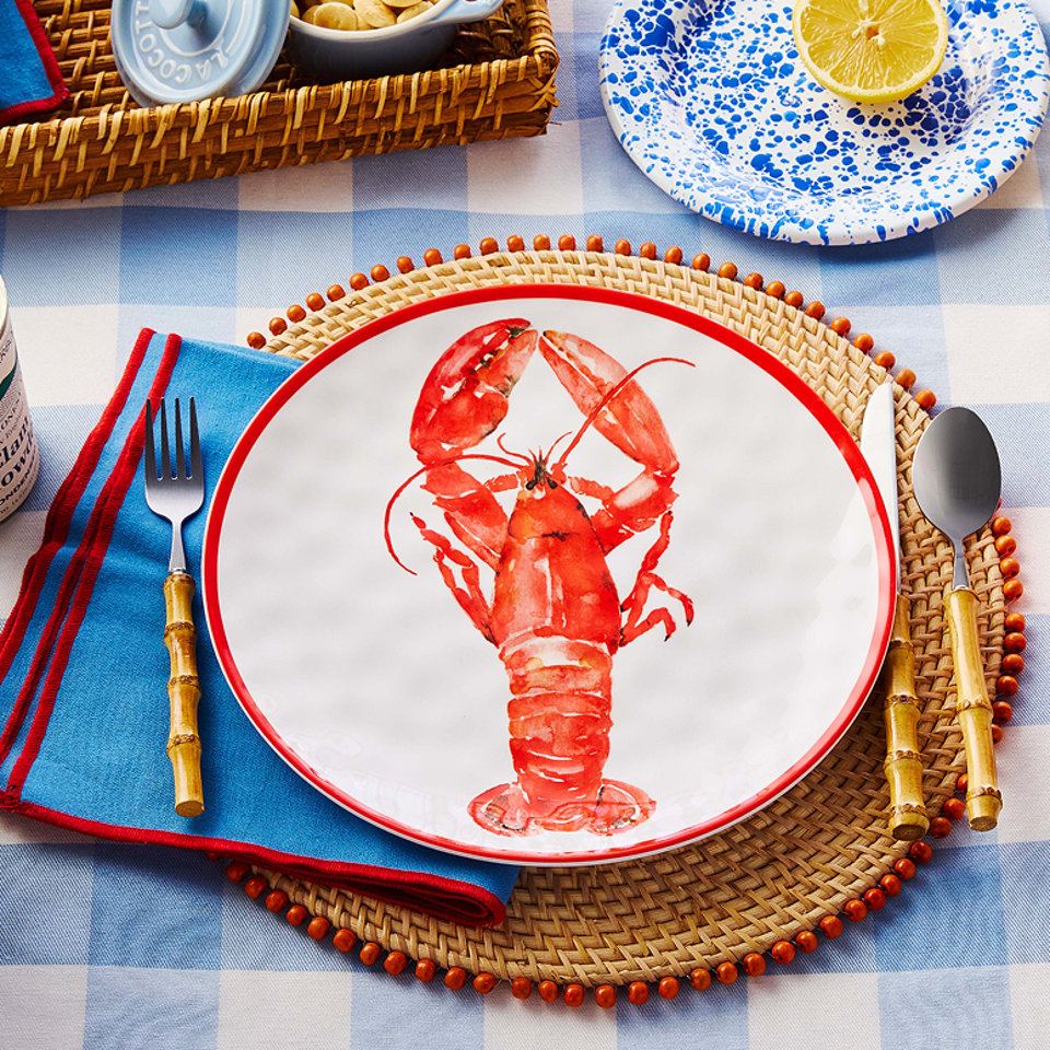 Summer table setting with lobster plate, bamboo flatware, and blue napkins