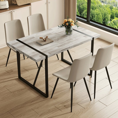 Ensemble de table et de chaises. Une table de salle à manger rectangulaire rétro minimaliste avec un plateau spécialement texturé et des pieds en métal noir.
