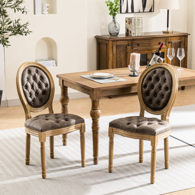 Deux chaises de salle à manger en cuir brun, une base en bois massif, une boucle ornée à la main, des sièges et des pieds en cuir, une structure et un coussin à ressorts en éponge