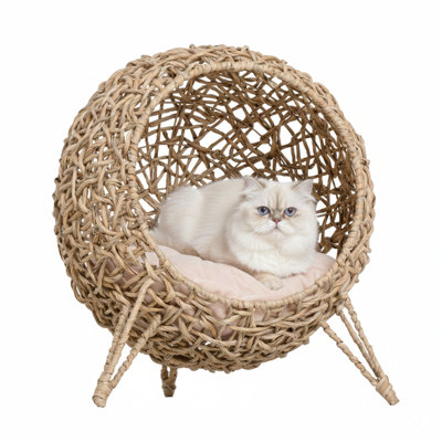 Une aire de repos surélevée de 20,5 pouces. Tissé à la main à partir de fibres de feuilles de bananier tressées. En forme de petite maison ou de condo et comprend un intérieur rembourré. Finition beige.