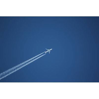 Blue Clear Sky & White Condensation Trail Of An Aircraft by Africanway - Wrapped Canvas Print