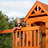 Backyard Discovery Atlantis Cedar Wood Swing Set with Wave Slide, Clubhouse, Rock Wall, and Sandbox Area