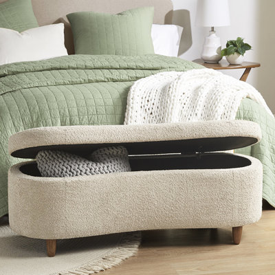 Banc de rangement spacieux à dessus rabattable en tissu texturé et fabrication en bois massif de couleur taupe à côté incurvé