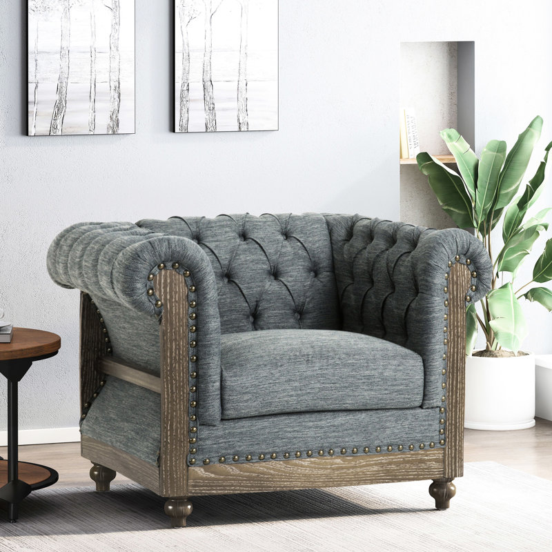 Élégant fauteuil club avec tissu gris anthracite, capitonnage à boutons profonds profonds, accoudoirs courbés, garniture cloutée, structure de pieds en bois de bouleau rafraîchissant, base intense