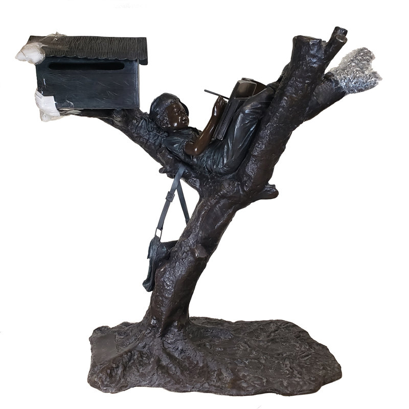 Statue bronze d'un garçon sur un arbre
