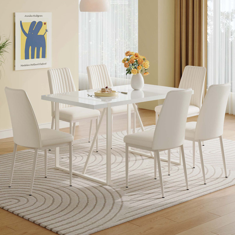 Ensemble de table de salle à manger en MDF blanc crème avec chaises sans accoudoirs. Le dossier de la chaise de salle à manger est conçu avec de multiples rayures verticales, ajoutant une atmosphère chaleureuse à votre famille.