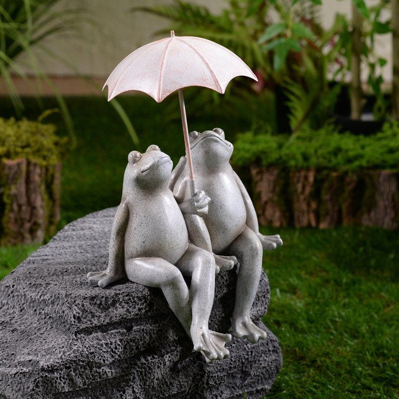 Statue de jardin assis avec quelques grenouilles et parasol
