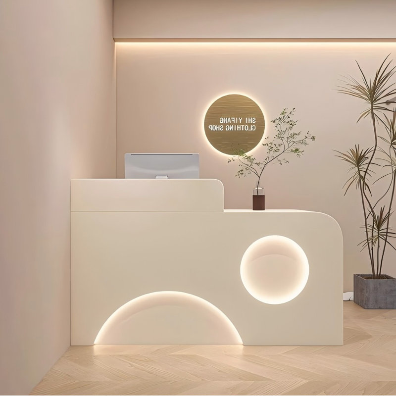 Casual and minimalist cream-coloured checkout counter with a curved design and baked paint finish