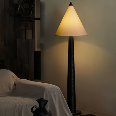 Une lampe sur pied en bois massif à côté du canapé dans le salon créatif