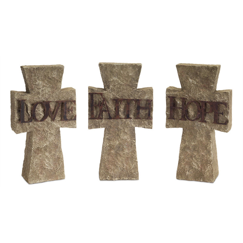 Ensemble de trois statues en forme de croix de ciment grise sur table
