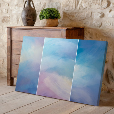 La toile crée une œuvre d'art abstraite mettant en vedette un doux mélange rêveur d'art mural de couleurs pastel, y compris des bleus pâle, des roses douces et de l'art mural sur toile crémeuse