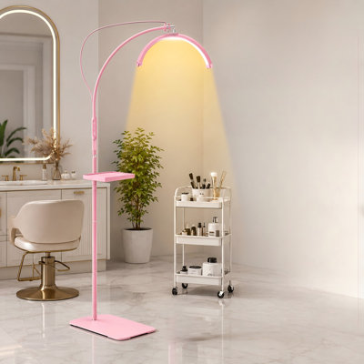 For salon eyelash-extension work, this pink 18In half-moon lash/ring light delivers 6500K LED illumination and includes a tray; its durable metal stand uses a 360° flexible gooseneck for positioning by lash artists.