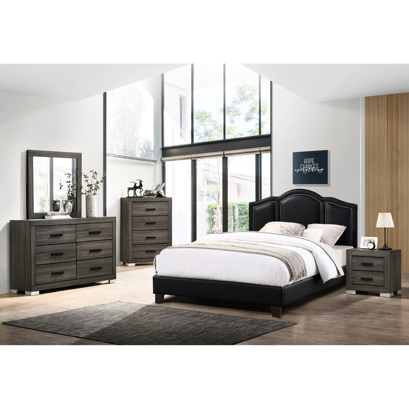 Grand lit noir avec rembourrage en similicuir et support en bois