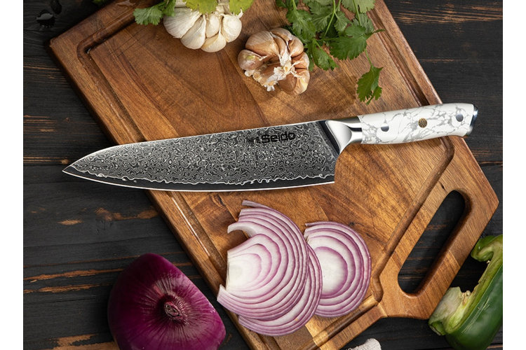 chef's knife on a cutting board with sliced onions
