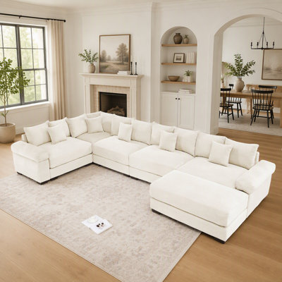 Canapé d'angle modulaire surdimensionné Cloud avec accoudoirs extra-larges, pouf et tissu velours côtelé haut de gamme pour un confort et une polyvalence ultimes.