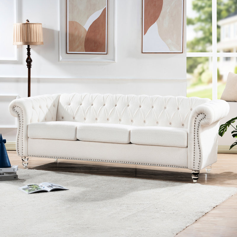 Accoudoirs roulés blancs de 84,44 po pour 3 sièges. Conforme à la norme Tb117. Boucles profondes et étirées qui maintiennent même le stress. Pieds en bouleau avec couche de joint de peinture facilitant le nettoyage des taches. Structure interne en pin massif et contreplaqué.
