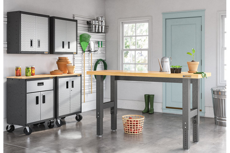 a garage with a wood-top workbench with garden tools on it