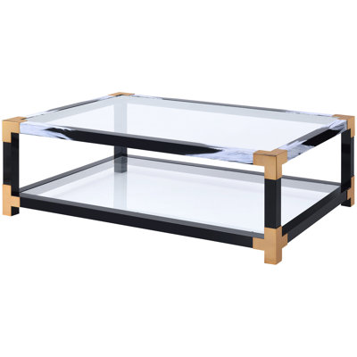 Table basse contemporaine avec dessus en verre, pattes en métal et étagère. Rangement élégant et transparent.