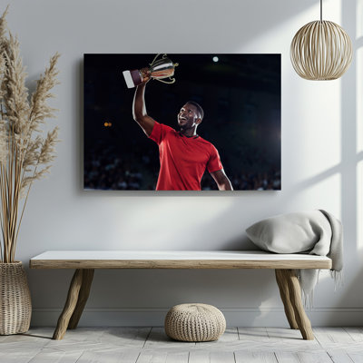 Canvas A Triumphant Athlete In A Vibrant Red Jersey Stands Center Wall Art Stage Holding A Gleaming Trophy High Above His Head Canvas Wall Art