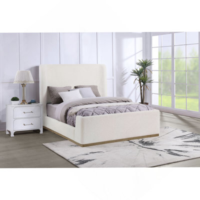Lit-bateau tapissier luxueux avec base en bois exposée, offrant confort, style et durabilité pour une chambre à coucher relaxante