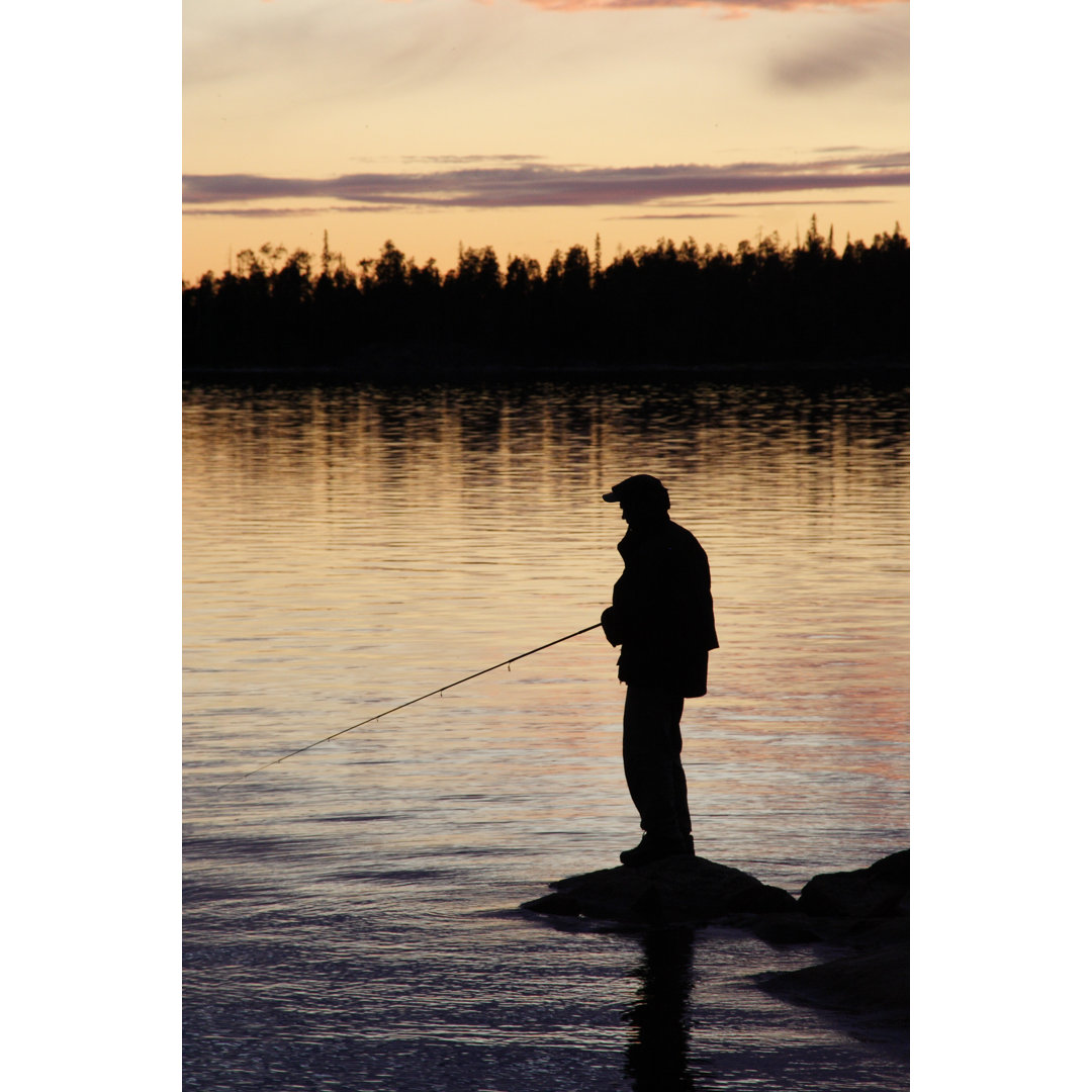 Silhouette eines Mannes beim Fischen in der Abenddämmerung