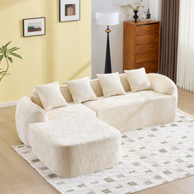L-Shaped Sofa With Curved Armrests And Four Throw Pillows.